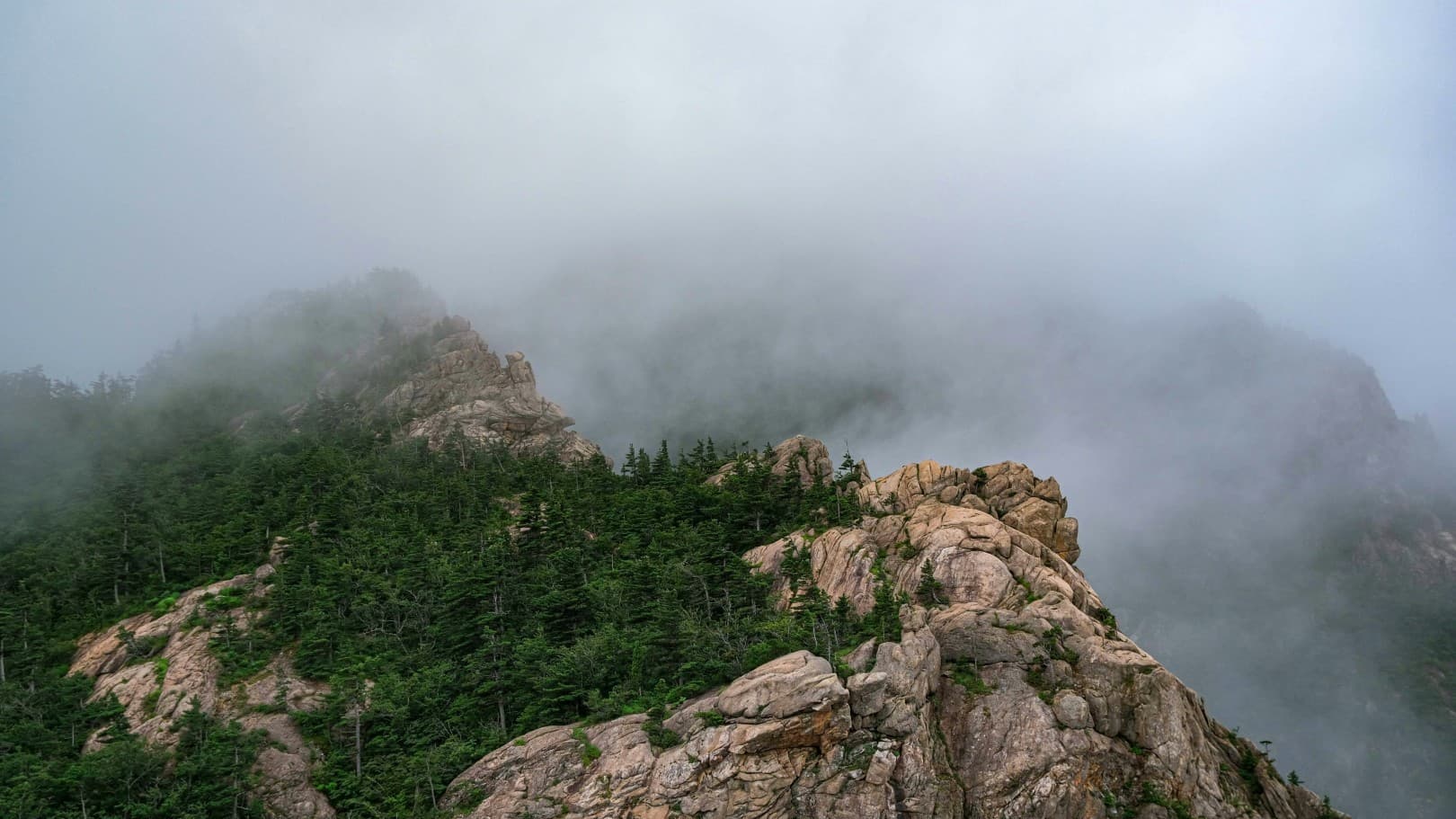 A photo of a mountain range in Korea with the morning fog.
